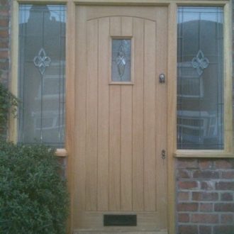 wooden front door with windows either side